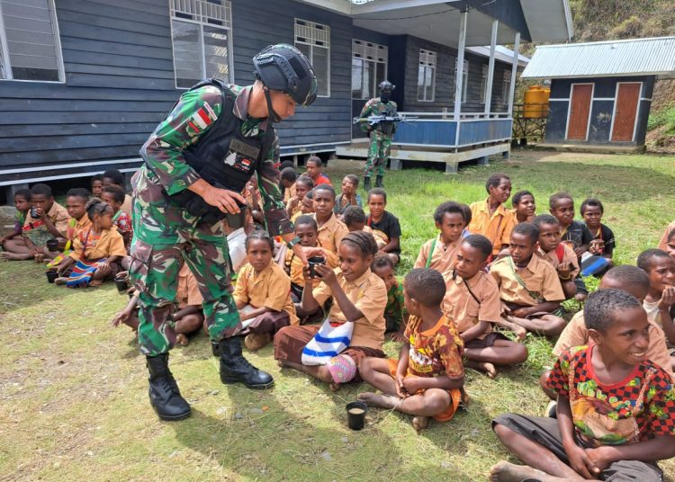 Satgas YR 142/KJ memberikan susu kepada anak-anak